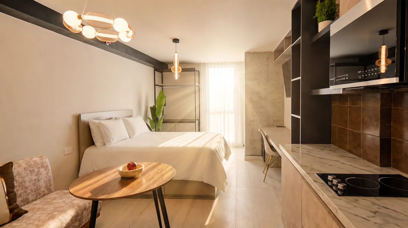 Habitación con dos camas, mesa de comedor y cocina integrada