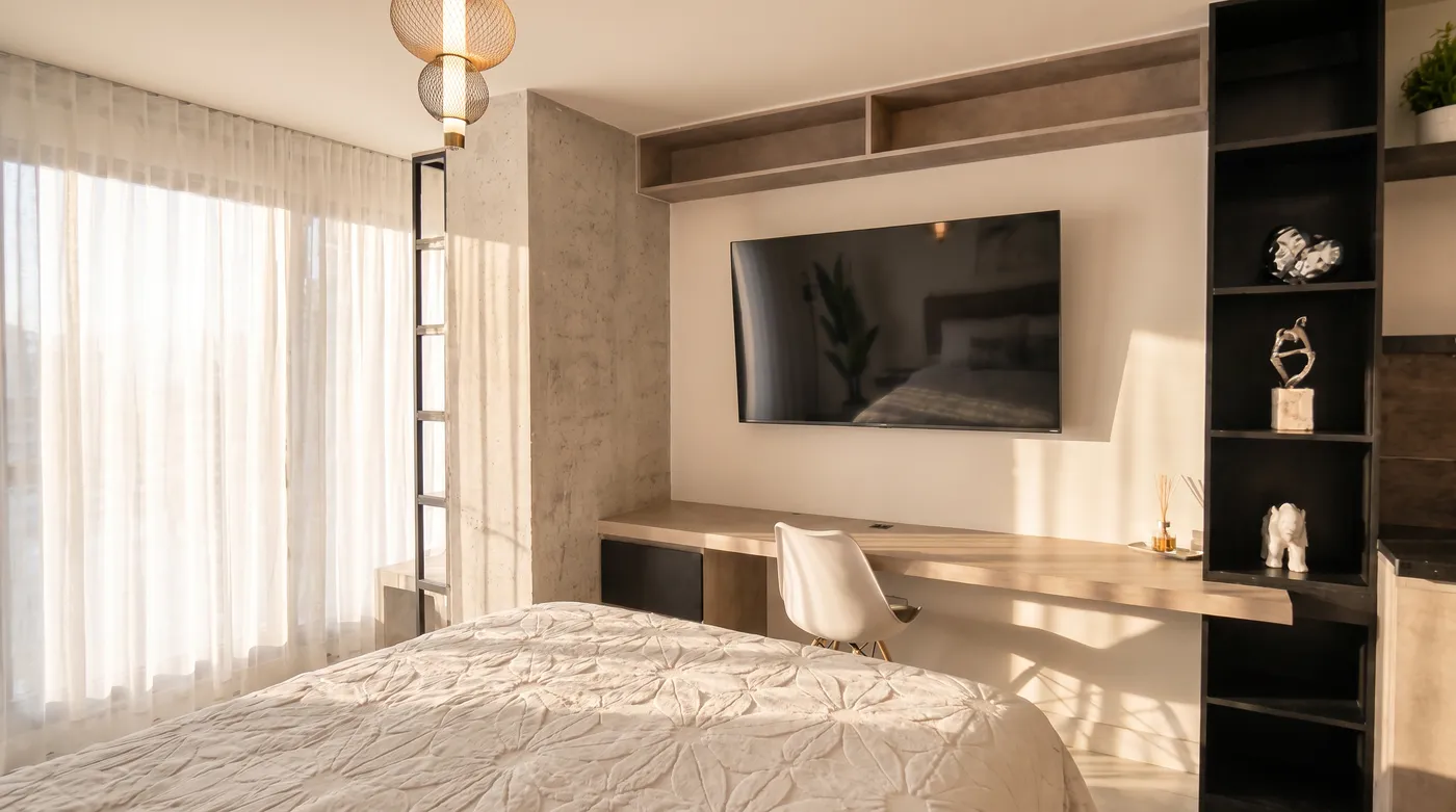 Habitación con escritorio, estantería negra y TV