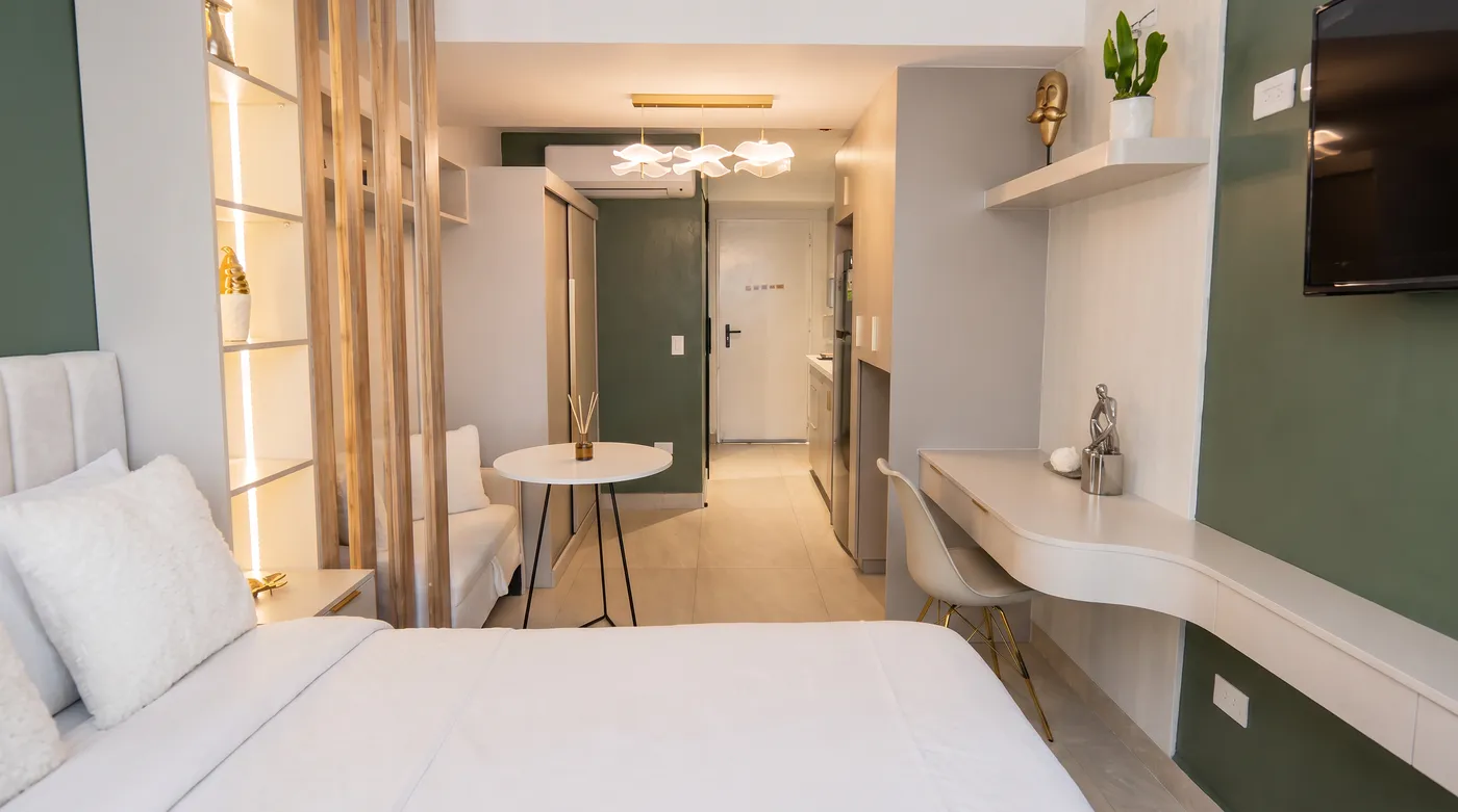 Habitación con pared verde, escritorio y zona de estar