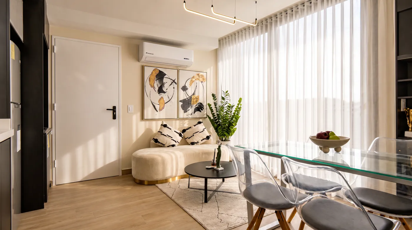 Sala con mesa de vidrio, cortinas y cocina al fondo