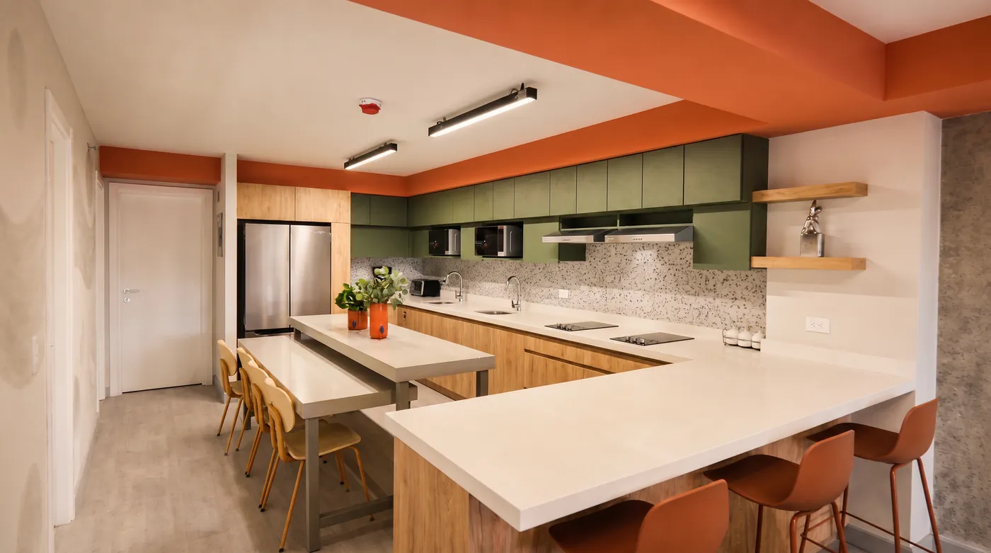 Cocina verde con barra y bancos coral