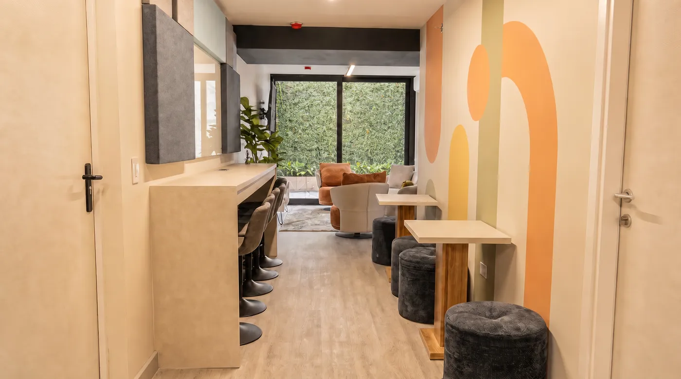 Área común real del coliving con barra, arcos de color y bancos